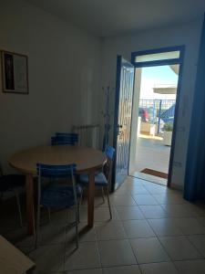 a dining room with a table and chairs and an open door at Appartamenti Piccola Stella Maris in Senigallia