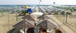 a beach with a bunch of umbrellas and chairs at Appartamenti Piccola Stella Maris in Senigallia
