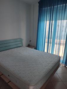 a bedroom with a bed with blue curtains and a window at Appartamenti Piccola Stella Maris in Senigallia