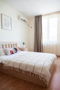 a bedroom with a large bed with a window at Kalina Apart in Sveti Vlas