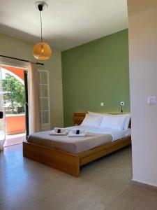 a bedroom with a large bed and a green wall at Alexandra's Apartments by Exclsv in Sidari