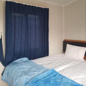 um quarto com uma cama com uma cortina azul em GÜN IŞIĞI KONAKLAMA em Hatay
