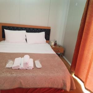 ein Schlafzimmer mit einem Bett mit zwei Paar Hausschuhen in der Unterkunft GÜN IŞIĞI KONAKLAMA in Hatay