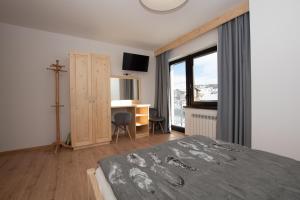 ein Schlafzimmer mit einem Bett, einem Schreibtisch und einem Fenster in der Unterkunft Pod Hawraniem Ski & Bike Friendly in Jurgów