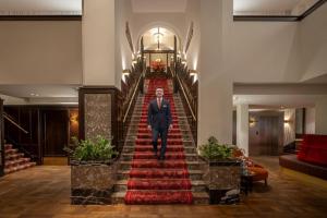 een man die een trap afloopt in een hotellobby bij Clayton Hotel Amsterdam American in Amsterdam