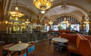 a bar in a restaurant with tables and chairs at Clayton Hotel Amsterdam American in Amsterdam