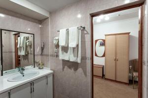 ein Bad mit einem Waschbecken und einem Spiegel in der Unterkunft Kurmet Hotel in Oral