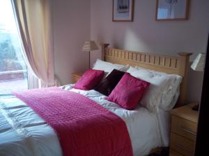 een slaapkamer met een bed met roze en witte kussens bij Grove Lodge B&B in Monaghan +13 foto's
