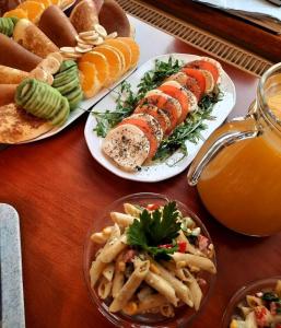 una mesa con tres platos de comida y zumo de naranja en Willa Podgórska, en Korbielów