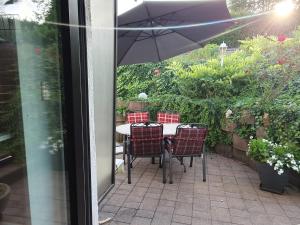 a table with chairs and an umbrella on a patio at Ferienwohnung Saarlandliebe in Lebach
