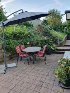 a table and chairs under an umbrella on a patio at Ferienwohnung Saarlandliebe in Lebach