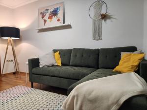 a living room with a green couch and yellow pillows at Ferienwohnung Saarlandliebe in Lebach