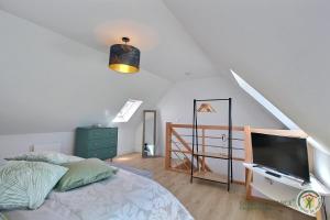 Schlafzimmer mit einem Bett und einem Flachbild-TV in der Unterkunft Chez tonton yves in Pleubian