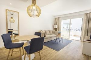 a living room with a couch and a table at Parque Nereida Suites Hotel in Cala Ratjada