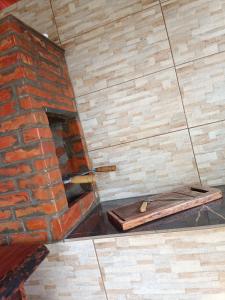 um forno de tijolo com uma tábua de madeira no chão em Chalé Pingo de Ouro em Alto Caparaó