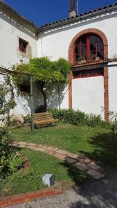 a bench in front of a building with a window at Belle Lauragaise ensoleillée in Issel