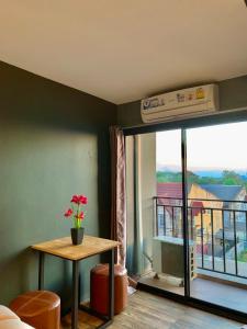 a room with a table and a view of a balcony at Dm Inn in Khon Kaen
