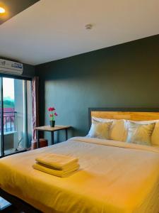 a bedroom with a large bed with yellow sheets at Dm Inn in Khon Kaen