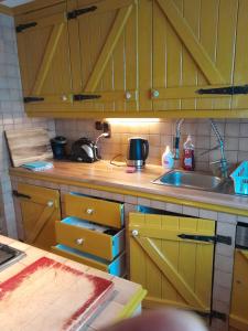 a kitchen with yellow cabinets and a sink at Villa-ház in Budapest