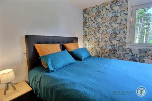 uma cama azul num quarto com uma janela em Luna em Paimpol