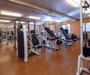 un gimnasio con varias filas de cintas de correr y máquinas en Ripamonti Residence & Hotel Milano, en Pieve Emmanuele