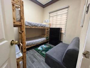 um quarto com 2 beliches e um sofá em Furutech Resort em Malolos