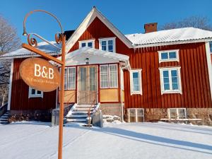 a sign in front of a red building in the snow at Hollands Län in Unnaryd