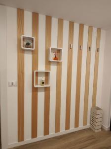 una habitación con una pared a rayas con estanterías. en Pit Stop 2k23, en Busto Arsizio