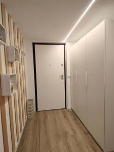 pasillo vacío con puerta blanca y suelo de madera en Pit Stop 2k23, en Busto Arsizio