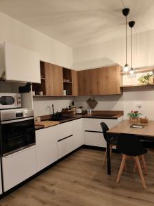 cocina con armarios blancos y mesa de madera en Pit Stop 2k23, en Busto Arsizio