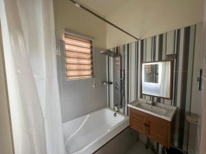 ein Badezimmer mit einer weißen Badewanne und einem Waschbecken in der Unterkunft Furutech Resort in Malolos