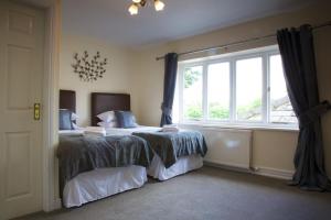 a bedroom with two beds and a window at The George Carvery & Hotel in Ripon
