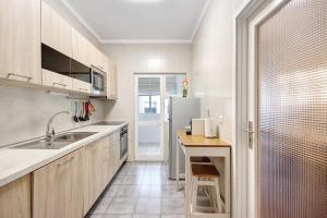 a kitchen with a sink and a refrigerator at Trindade Porto City Centre in Porto