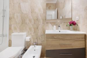 a bathroom with a white toilet and a sink at Trindade Porto City Centre in Porto