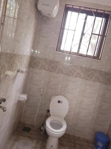 a bathroom with a white toilet and a window at UPENDO MANYARA SAFARI LODGE in Mto wa Mbu