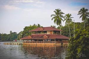 a large building on the water with palm trees at Annie's Villa in Kovalam