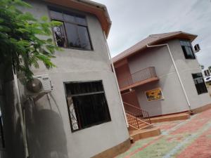 Edificio blanco con ventana y balcón en UPENDO MANYARA SAFARI LODGE en Mto wa Mbu
