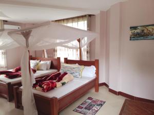 ムトワンブにあるUPENDO MANYARA SAFARI LODGEのベッドルーム1室(天蓋付きベッド2台付)