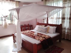 1 dormitorio con 1 cama con dosel en UPENDO MANYARA SAFARI LODGE, en Mto wa Mbu