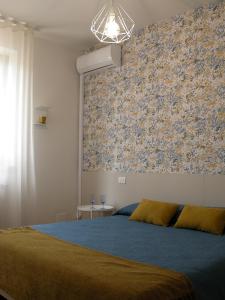 a bedroom with a blue bed and a floral wall at Agriturismo La Masseria - La casa tra gli alberi in Cugnoli