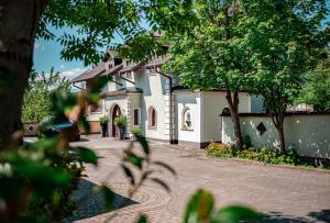ein großes weißes Haus mit Bäumen davor in der Unterkunft Gasthof Pöchhacker in Steyr