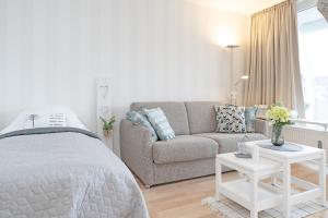 ein Schlafzimmer mit einem Bett, einem Sofa und einem Tisch in der Unterkunft Appartementanlage Kammerweg 5-5b Kleinaberfein in Scharbeutz