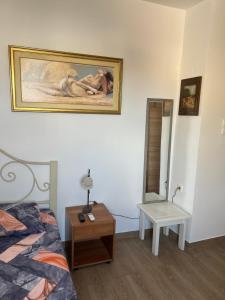 a bedroom with a bed and a painting on the wall at Private Rooms with a Beautiful Veranda in Heraklio Town