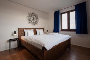 1 dormitorio con 1 cama grande y cortinas azules en PALAVIA Apartments, en Pavlov
