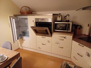 a kitchen with an open refrigerator and a microwave at Das Tor zur Rhön in Dietlas