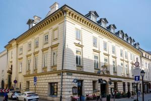 un grand bâtiment blanc au coin d'une rue dans l'établissement N33 Premium Apartments Old Town Kraków, à Cracovie