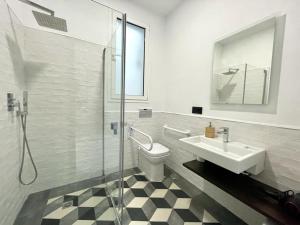 La salle de bains est pourvue d'un lavabo, de toilettes et d'une douche. dans l'établissement Eva Recommends Triana, à Séville