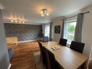 comedor con mesa de madera y sillas en 2 Bedroom Apartment near Glasgow Airport, en Renfrew