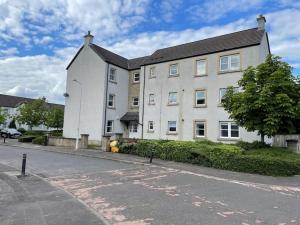 a large white building on the side of a street at 2 Bedroom Apartment near Glasgow Airport in Renfrew