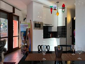 a kitchen with a table with wine glasses on it at Lakeside Design Apartment Casa Manola - Larihome A44 in San Siro
